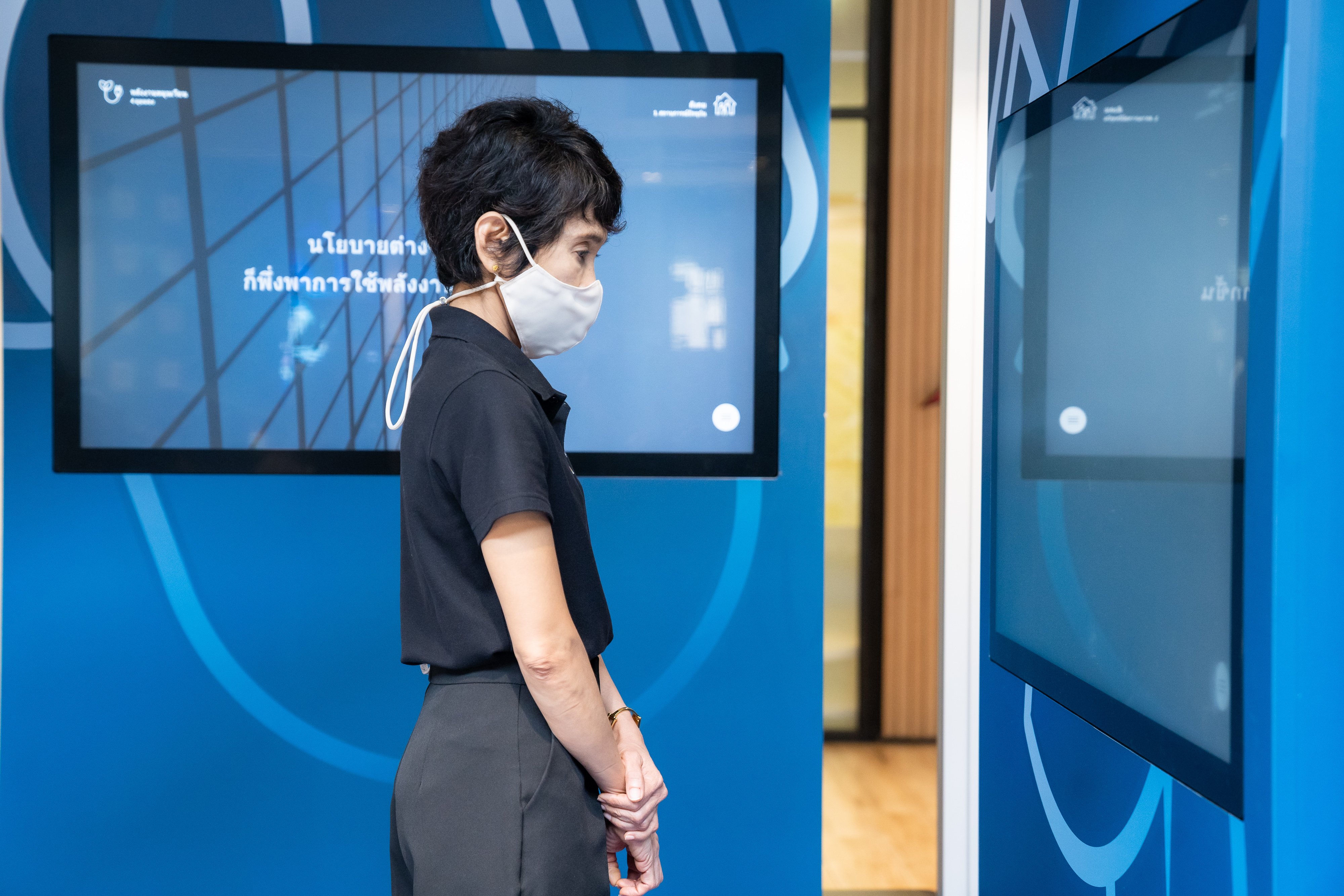 Eine Besucherin an der Station Renewable Energies in Bangkok und schaut auf einen Bildschirm. März 2021.